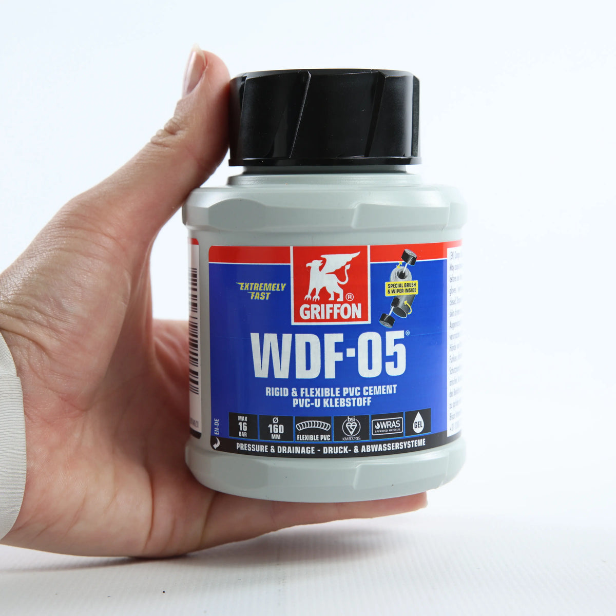 Клей для flex PVC_ABS Griffon WDF-05 0,25 л — банку тримають рукою, фронтальний вигляд упаковки